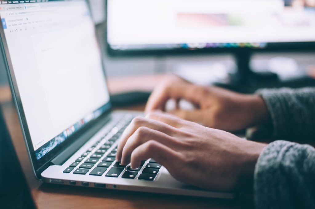 Student typing a statement of purpose on a laptop for a university application